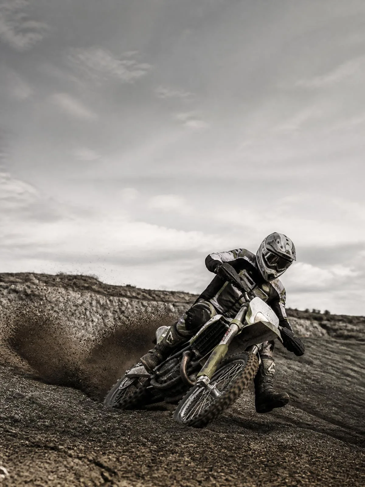 Motocross rider carving through rough terrain